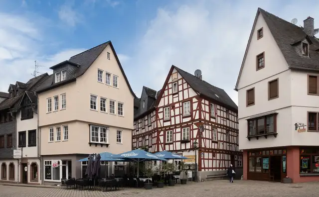 Half-timbered houses and café umbrellas on the Plötze square in Limburg an der Lahn.